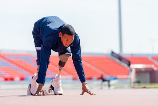 Front side view of sport man athlete with a prosthesis on his leg action of start to run on the track at the stadium. Sport concept.
