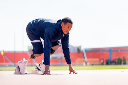 Side view of sport man athlete with a prosthesis on his leg action of start to run on the track at the stadium. Sport concept.