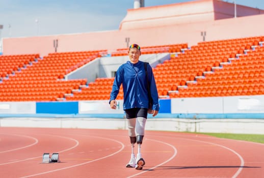 Sport man athlete prosthesis legs carry the bag and walk on the track of the stadium with day light and happiness.