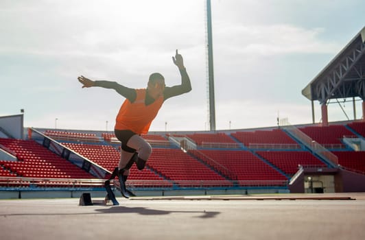 Sport man athlete prosthesis legs start run with look forward at the stadium with soft light of evening.