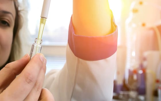 A female laboratory assistant uses a special pipette to work with biomaterial. Analysis of liquids.