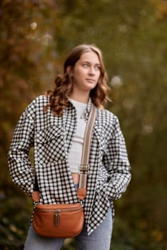 Autumn Elegance: Girl with Warm Tones, Casual Style, and a Park Stroll. ashion trends, autumn style, casual elegance, outdoor fashion, trendy accessories, park lifestyle, cozy vibes, seasonal warmth, stylish look, autumnal hues