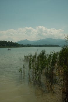 Gorgeous view of the Chiemsee in Bavaria, Germany with a tiny boat sailing across it on a sunny day