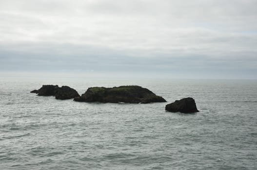 Scenic view of Icelandic peninsula with waves hitting black rocks at overcast Dyrholaey Cape