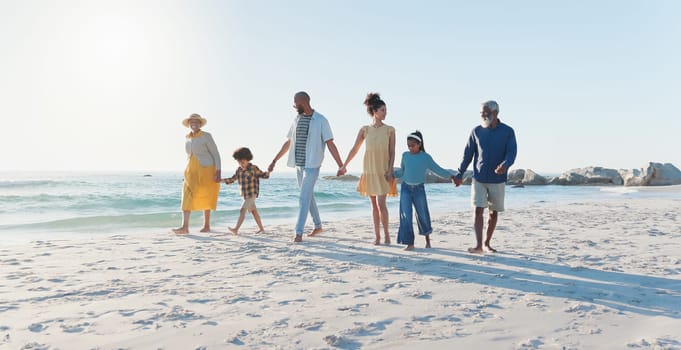 Holding hands, walking and big family at the beach on vacation, adventure or holiday together. Love, travel and children with parents and grandparents on the sand by the ocean or sea on weekend trip