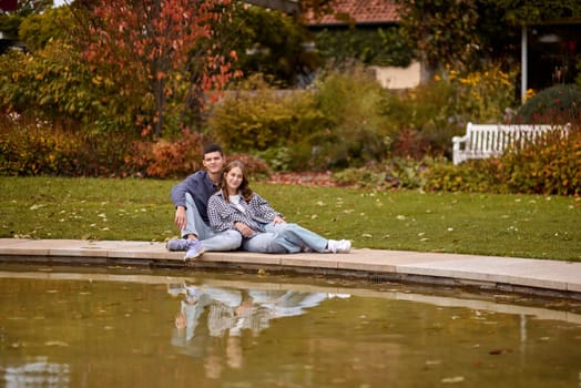 lovely young couple kissing outdoors in autumn. Loving couple walking in nature. Autumn mood. Happy man and woman hugging and kissing in autumn. Love. Fashionable couple outdoors. Fashion, people and lifestyle. Stylish couple in autumn outfit.