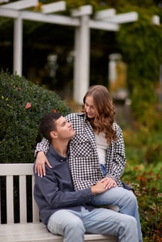 lovely young couple kissing outdoors in autumn. Loving couple walking in nature. Autumn mood. Happy man and woman hugging and kissing in autumn. Love. Fashionable couple outdoors. Fashion, people and lifestyle. Stylish couple in autumn outfit.