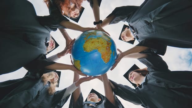 The concept of a world without war. College graduates holding a geographical globe of the world