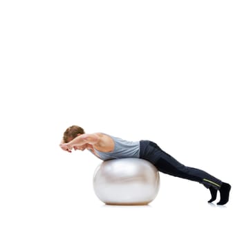Yoga ball, sports and man in a studio with a body, health and wellness exercise for balance. Fitness, equipment and young male athlete with stretching workout or training isolated by white background.