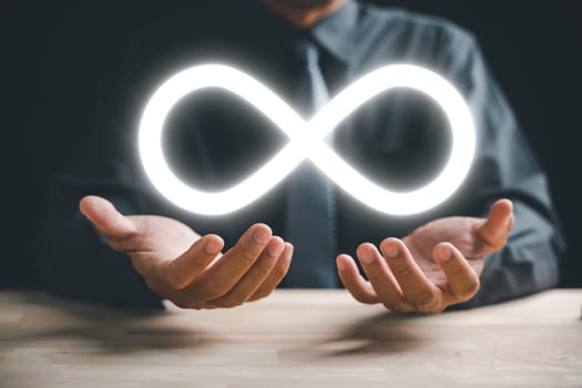 Circular infinity symbol held by businessman, representing circular economy and infinite potential. Strategy of sustainable investment, banking, and financial growth. technology infinity data