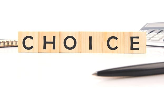 CHOICE WORD word assembled from wooden cubes next to a calculator, pen and notepad