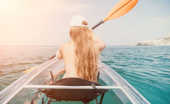 Woman in kayak back view. Happy young woman with long hair floating in transparent kayak on the crystal clear sea. Summer holiday vacation and cheerful female people having fun on the boat.