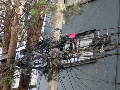 Mexico City, Messed up power lines and connection cables. Many tangled wires on electric poles in the city