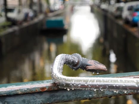 A bicycle handlebar on canals of Amsterdam view on rainy day