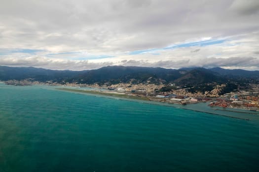 Airport of Genoa Italy aerial view before landing to airport by airplane during a sea storm tempest hurricane