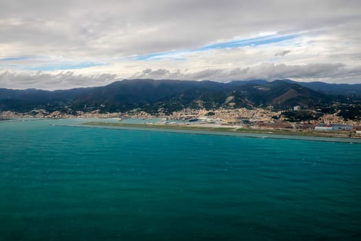 Airport of Genoa Italy aerial view before landing to airport by airplane during a sea storm tempest hurricane