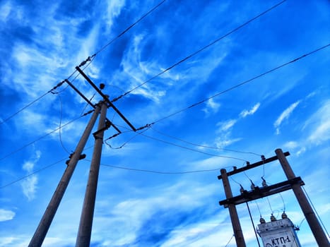 Old power poles and the sky with clouds in the background. Electric lines, towers, wires in landscape