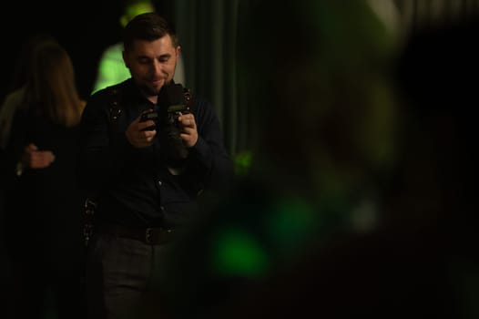A photographer at work, the process of shooting and photographing celebrations, a photographer with a camera. paparazzi conducts a journalistic investigation at a party.