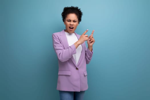 young successful positive office woman dressed in jacket points finger at wall space.