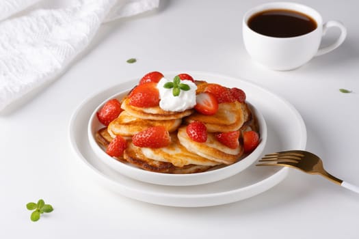 Mini pancakes with strawberry and sour cream.