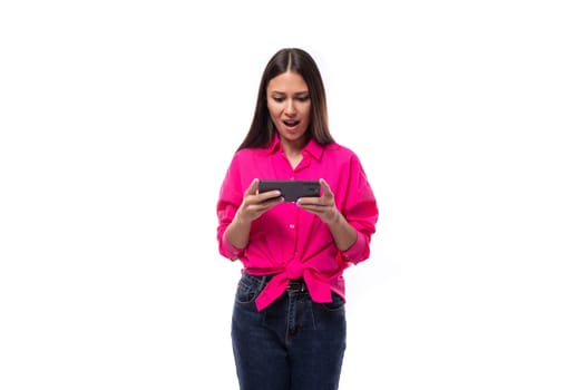 fashionable slim young employee office woman dressed in a pink shirt watching video on the phone.