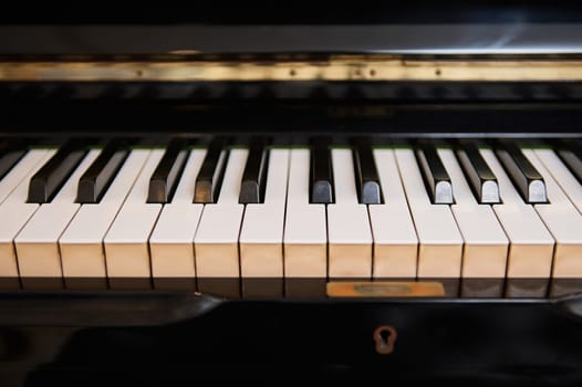 Close-up front view of classic grand piano keyboard. Ebony and ivory pianoforte keys. Chord musical instrument. Still life