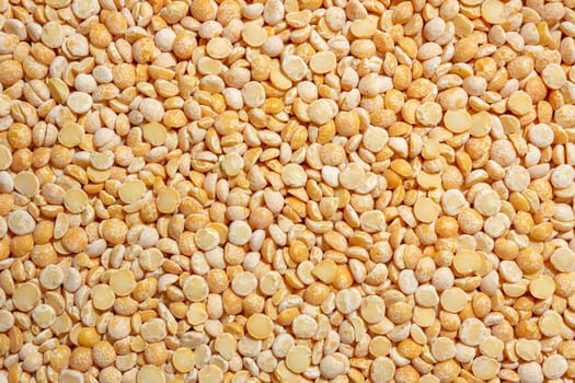 Uncooked Polished Split Peas Background. A Culinary Canvas of Dry Yellow Peas, Creating a Lively and Textured Background for Gourmet Cooking. Scattered Raw Polished Peas. Healthy Eating Ingredients