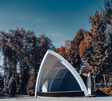 Park outdoor opening cinema theatre concept photo. Theater in autumn with trees in parkland. Idyllic scene. High quality picture for wallpaper, travel blog