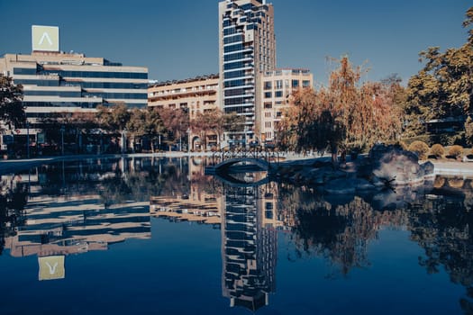 Cityscape in a day time close up view in full color photo. Beautiful urban scenery from parkland photography. District scene near lake. High quality picture for magazine, article