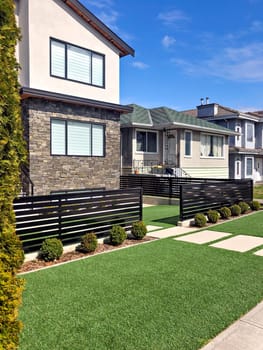 Residential family house with concrete pathway over front yard. Family house on sunny day in British Columbia, Canada