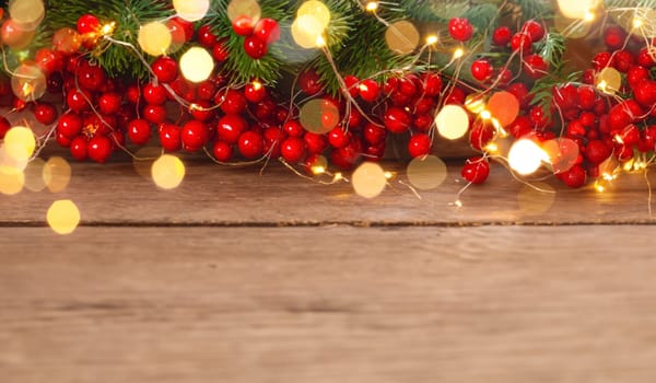 wooden background with christmas decoration as red berries and bokh lights