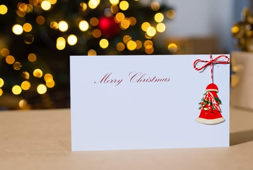 white card with copy space and merry christmas text on bokeh background