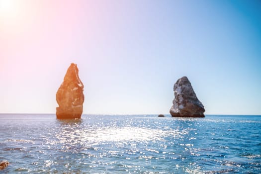 Two rocks stick out of the water in the middle of the turquoise sea. Scenic ocean views. High quality photo. Like in Iceland.