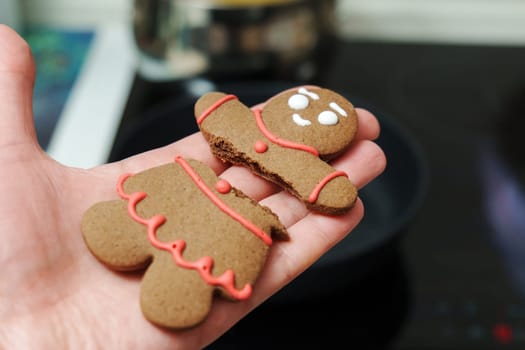 Holding a broken gingerbread man. Close-up, selective focus, Christmas