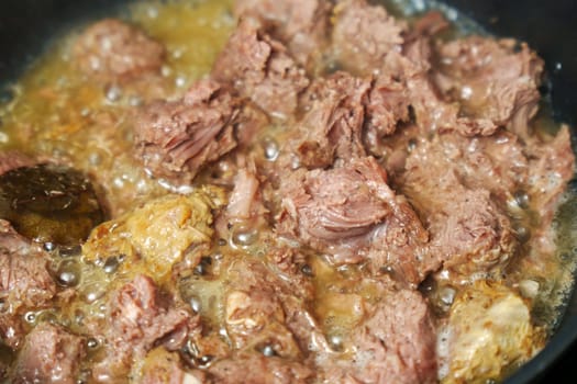 Cooking stewed canned meat in close-up. Canned food