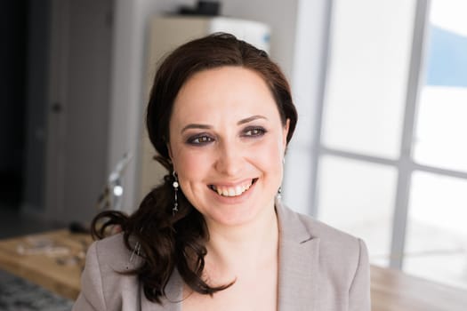 Portrait of a female online store business owner looking away and smiling. Woman doing her small business from home