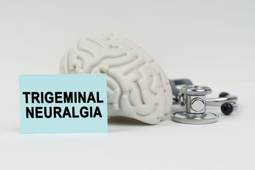 Medical concept. On a white surface next to the brain there is a stethoscope and stickers with the inscription - Trigeminal neuralgia