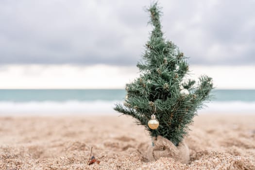 Sea Decorated Christmas tree on sandy beach. Christmas, New Year holidays concep