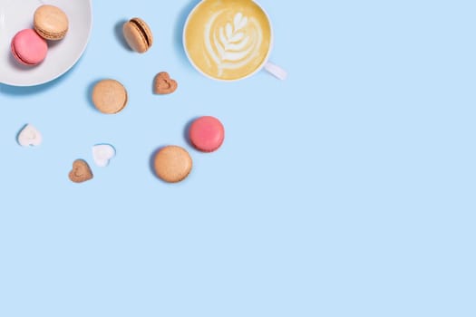 Blue background with macaroons, sugar and cup of coffee. Top view with space for your text.