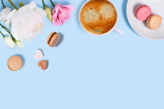 Blue background with cup of tasty coffee, macaroons, peonies and roses. Top view with space for your text.