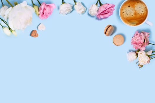 Blue background with cup of tasty coffee, macaroons, peonies and roses. Top view with space for your text.