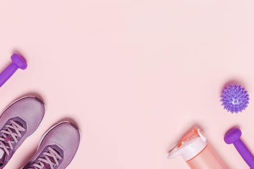 Sports equipment for training at home. Pink background, diagonal composition.