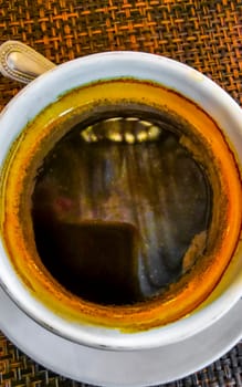 Glass cup of americano black coffee with spoon and plate on table food and drink in the restaurant cafe in Playa del Carmen Quintana Roo Mexico.