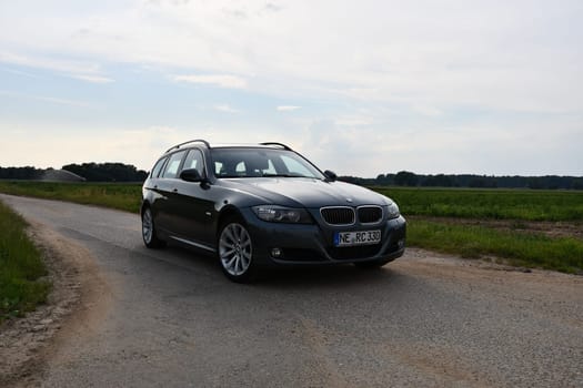 BMW 330d, E91, touring green-gray station wagon on country lane