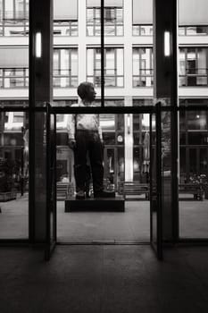 Large sculpture of an office worker in a glass courtyard in Berlin, Germany