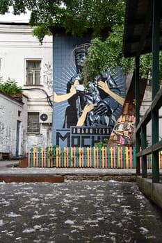 Vertical shot of graffiti on a building wall in backyard