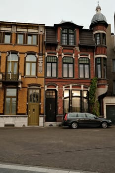 A vertical shot of a car in front of old townhouse at the sunset in Venlo, Netherlands