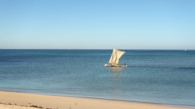 Anakao, Madagascar - May 03, 2019: Calm sea with piroga - traditional wooden fishing boat used on this African island, more boats in background. Fishes are one of main food sources in this region