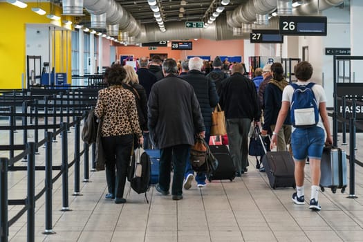 London, United Kingdom - February 05, 2019: View from back to group of passengers walking to the gate before boarding the airplane at London Luton, 5th busiest airport in UK