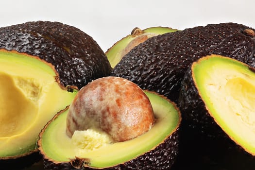 Closeup detail of avocado - Hass / Bilse variety - pit visible in halved pears